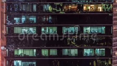 办公室摩天大楼在深夜外景，<strong>室内灯</strong>亮着，人们在夜间工作